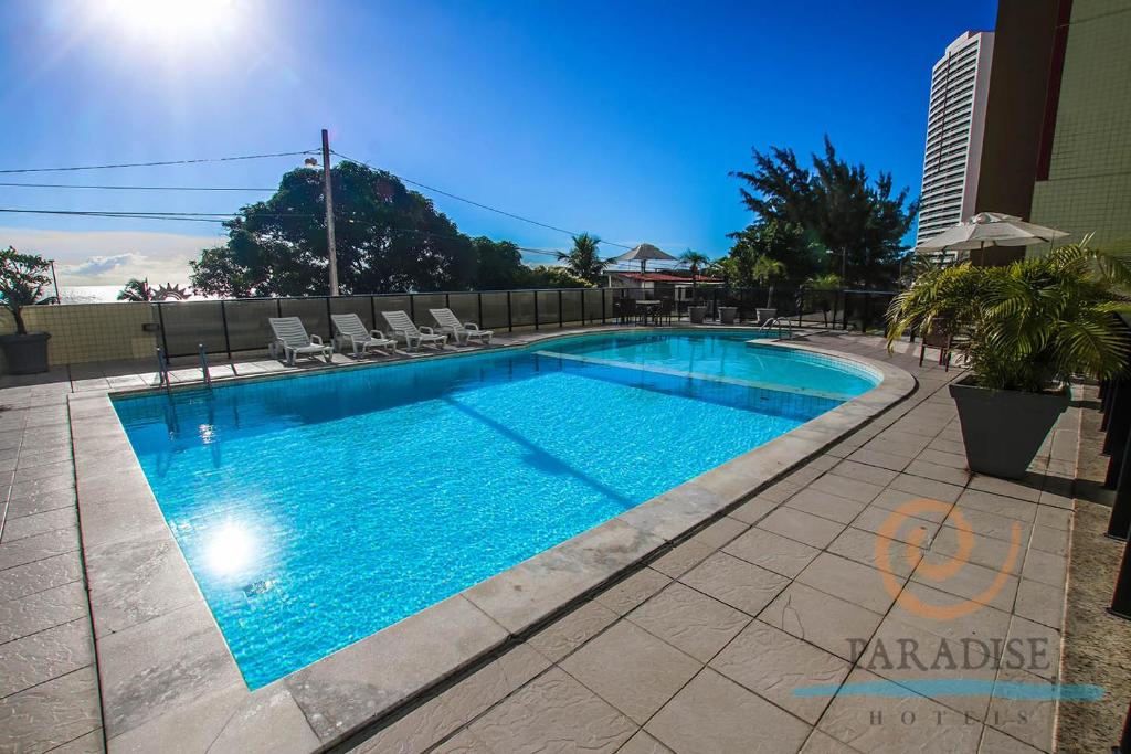 a large swimming pool with lounge chairs in a building at Paradise Flat in Natal
