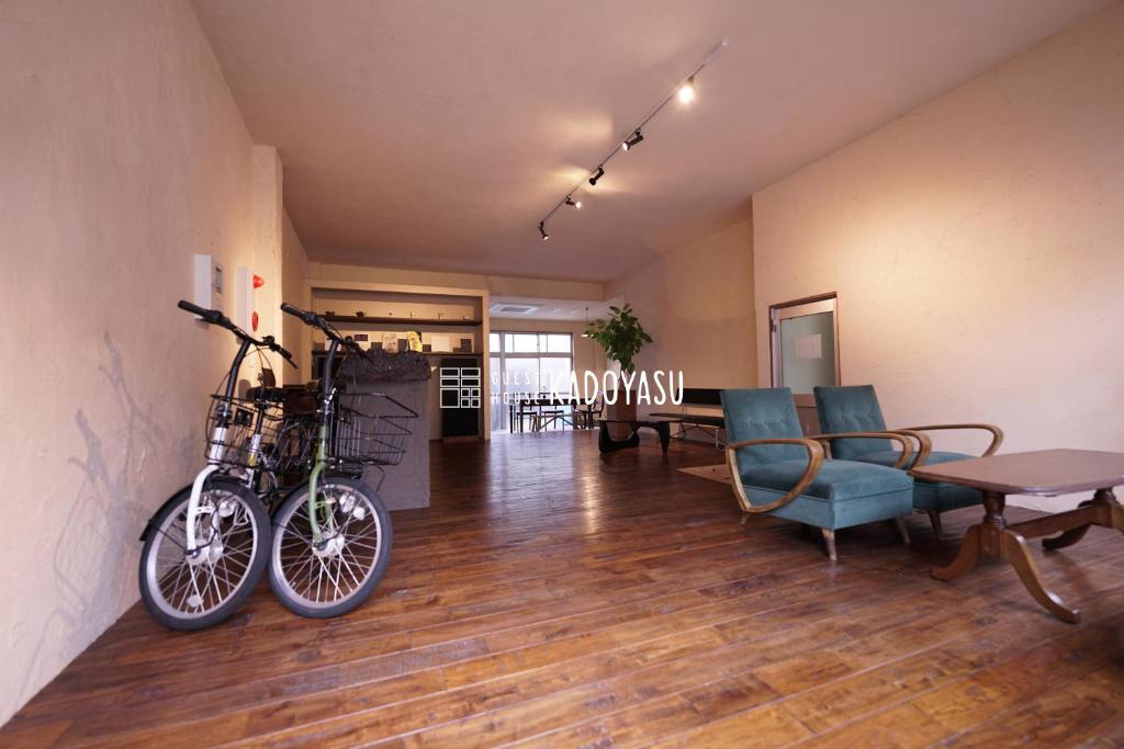 a living room with two bikes hanging on the wall at Guest House Kadoyasu in Kanazawa