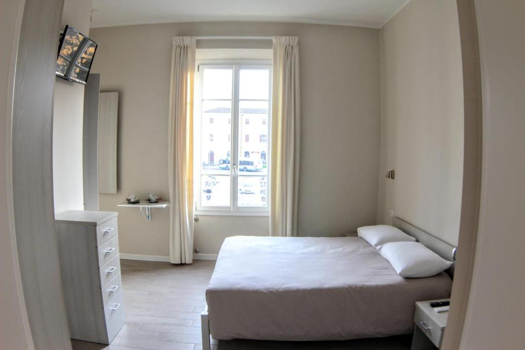 ein kleines Schlafzimmer mit einem Bett und einem Fenster in der Unterkunft Affittacamere Stazione Empoli in Empoli