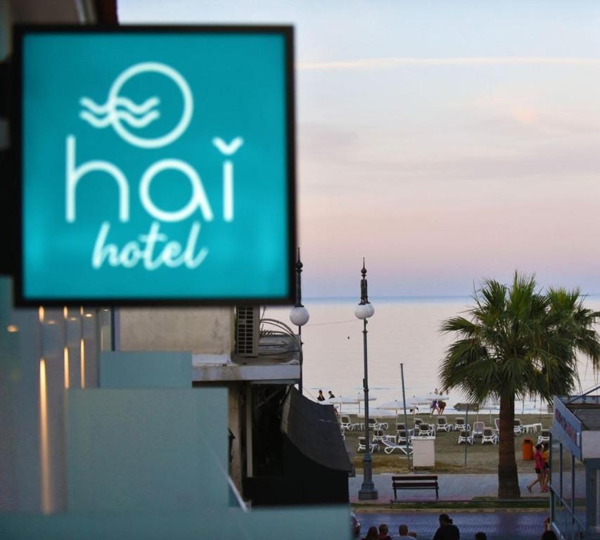 a sign on a building with a beach in the background at Hai Hotel in Larnaka