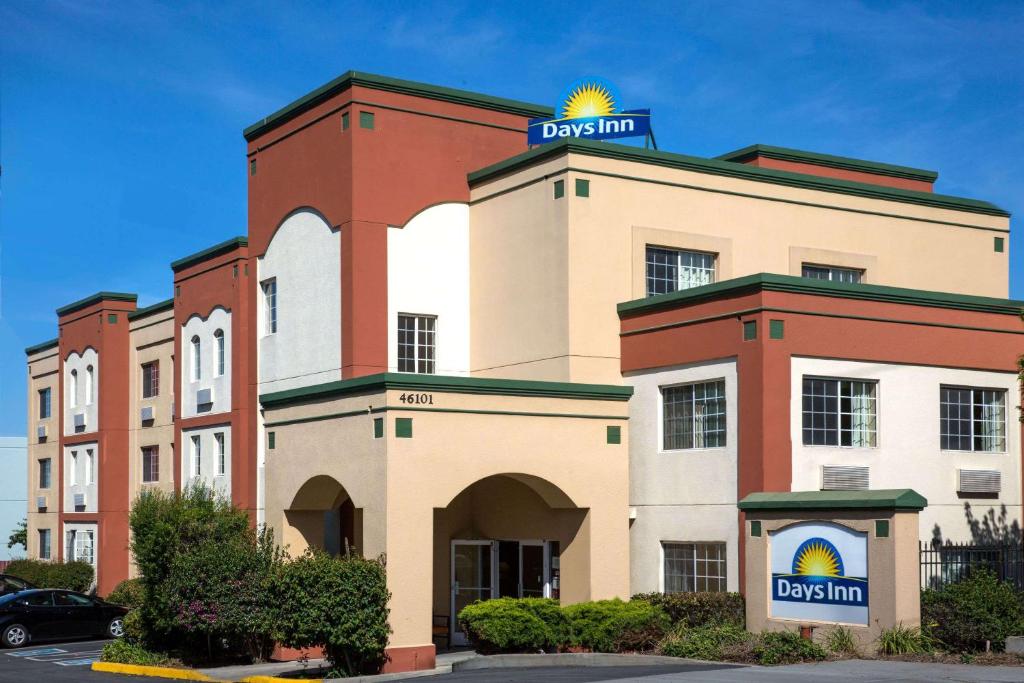 a building with a sign on top of it at Days Inn by Wyndham Fremont in Fremont