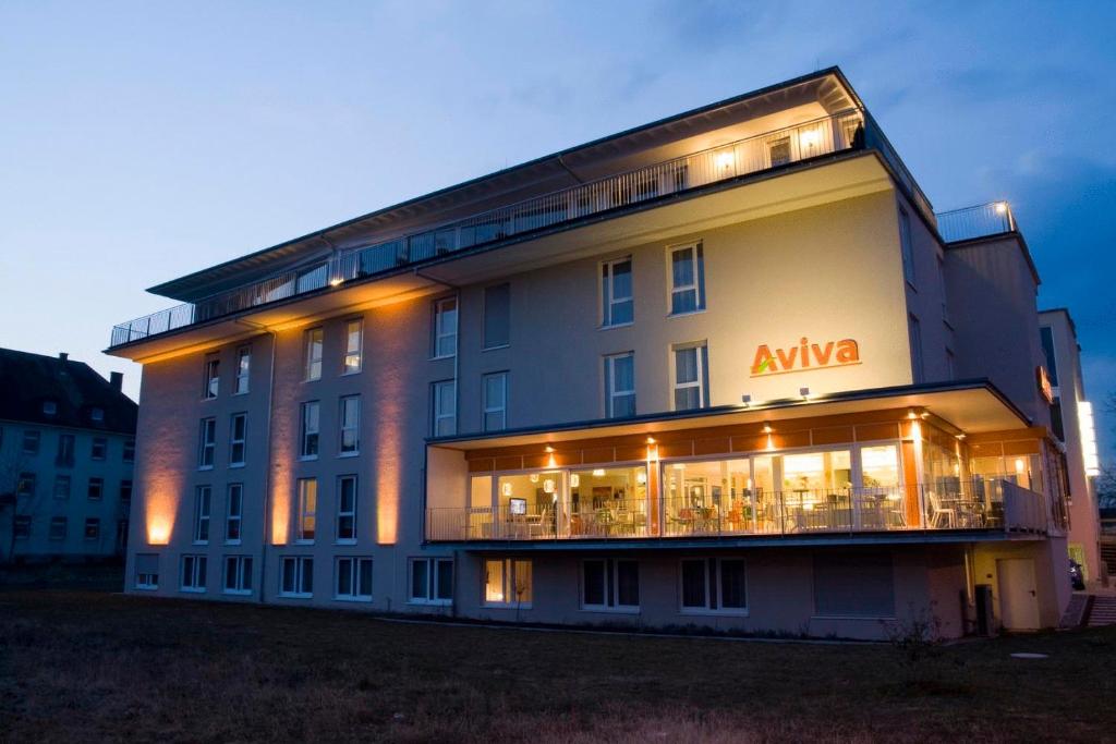 un grande edificio con un cartello di Aania sul lato di Hotel Aviva a Karlsruhe