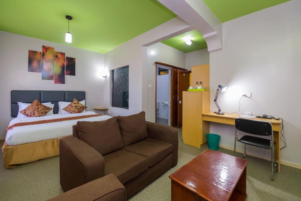 - une chambre avec un lit, un canapé et un bureau dans l'établissement Maple Inn Hotel, à Nairobi