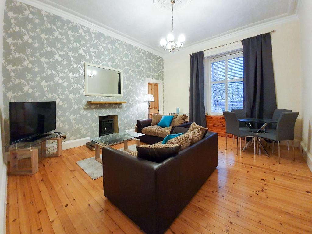 a living room with a couch and a television at Linburn House Apartment in Dunfermline