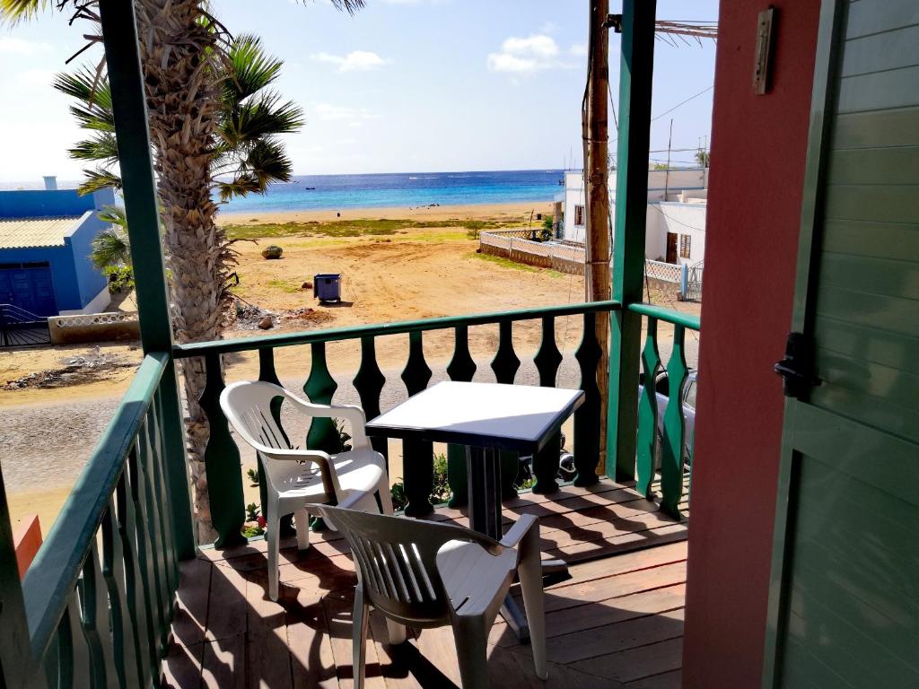 a balcony with a table and chairs and the beach at Sal service Ibiscus Beach Ocean View Apartment in Santa Maria
