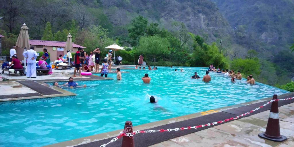 a group of people in a swimming pool at Aloha Serenity Apartments in Rishīkesh
