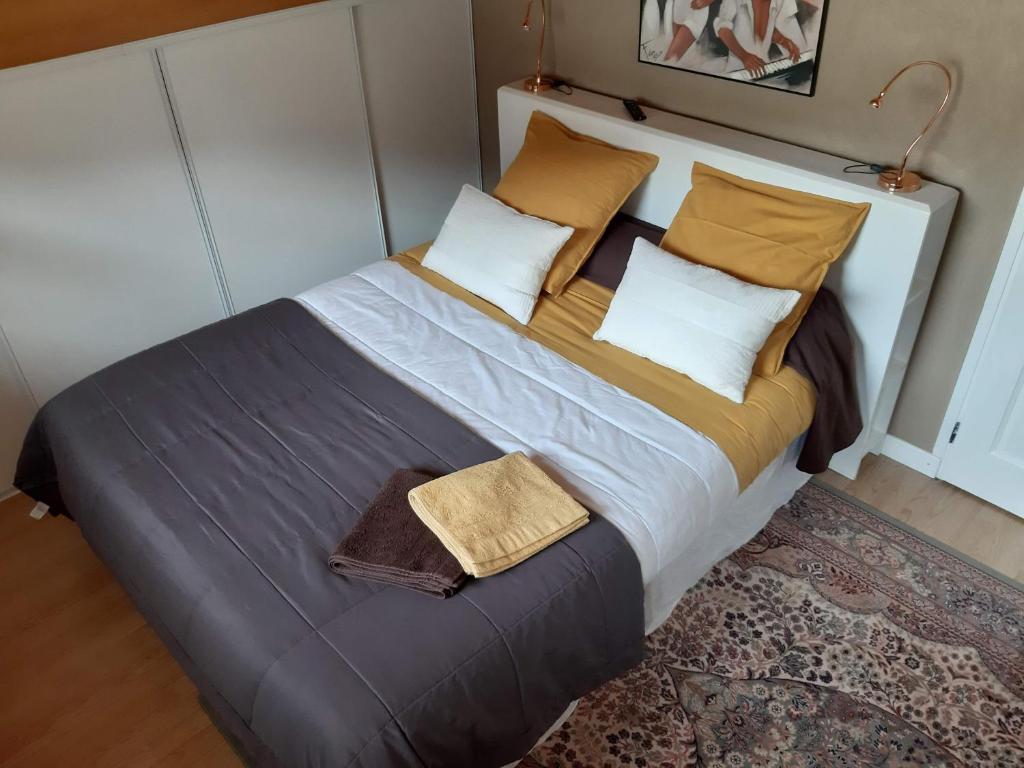 ein großes Bett mit zwei Kissen und einer Decke in der Unterkunft "NAMASTE" Chambre zen au calme in Saint-Jean-dʼAulps