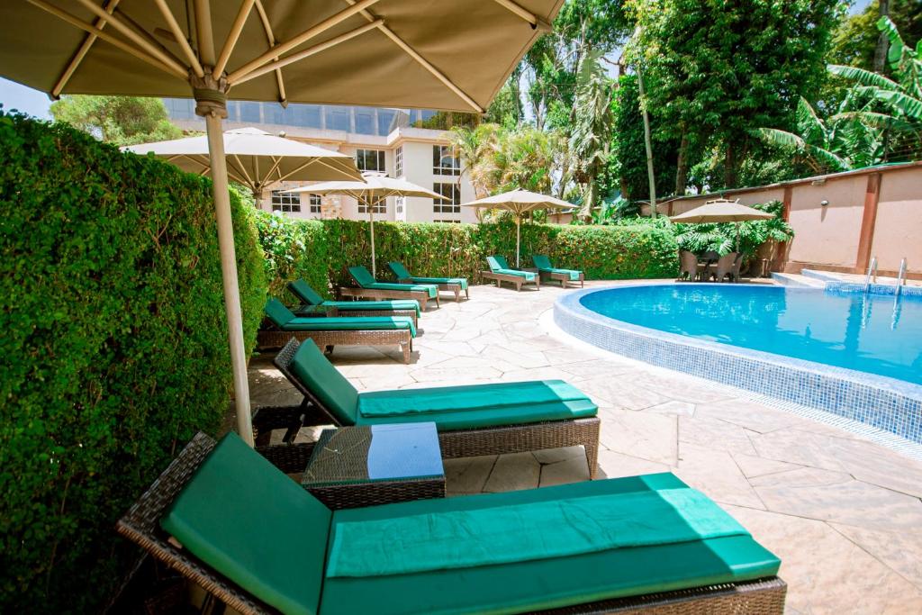 a row of chairs with umbrellas next to a swimming pool at SG Premium Resort in Arusha