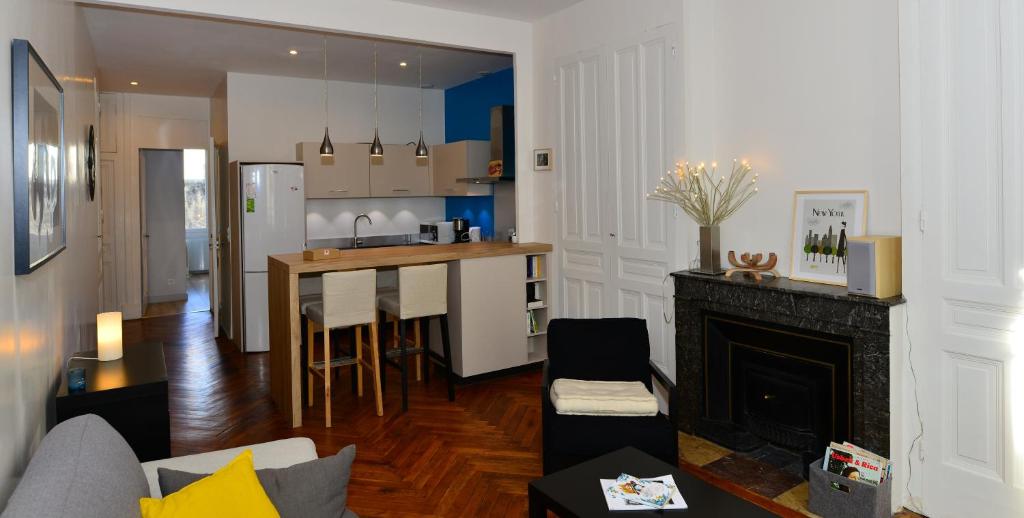 a living room with a fireplace and a kitchen at Appart' Anvers in Lyon
