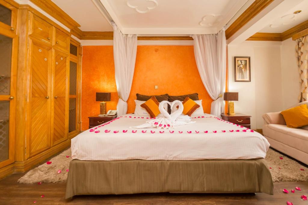 um quarto com uma cama grande com rosas vermelhas em Marble Arch Hotel em Nairobi