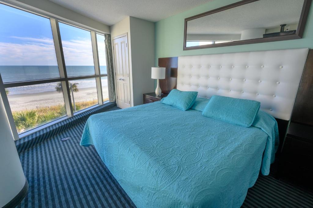 um quarto com uma cama e vista para a praia em New Ocean Front Corner Unit em Myrtle Beach