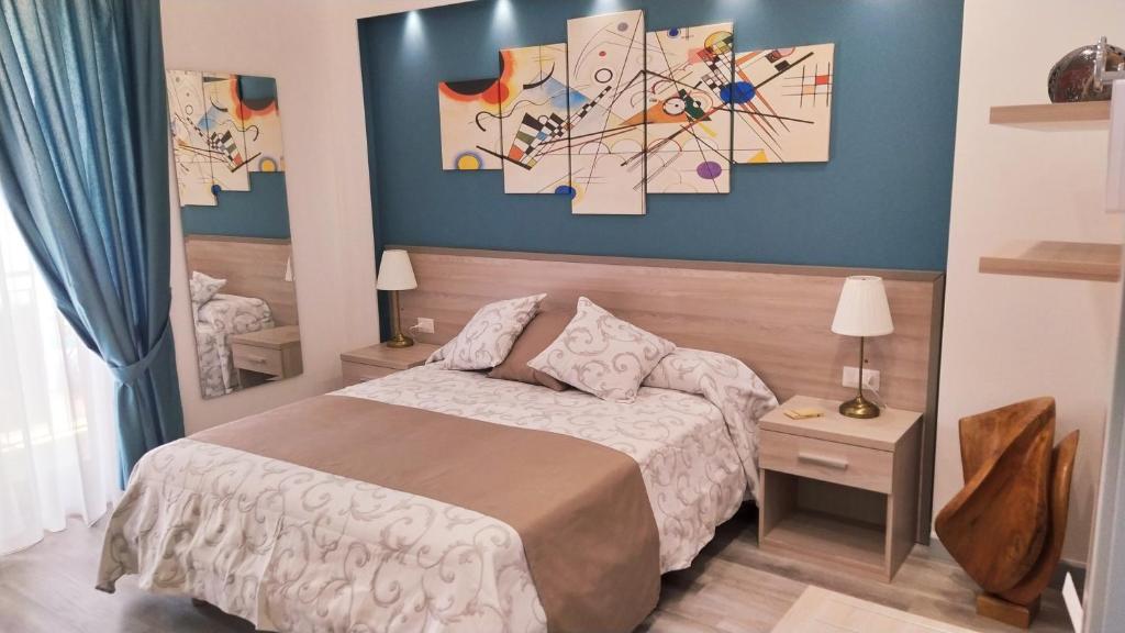 een slaapkamer met een bed en schilderijen aan de muur bij B&B La Stazione in Diamante