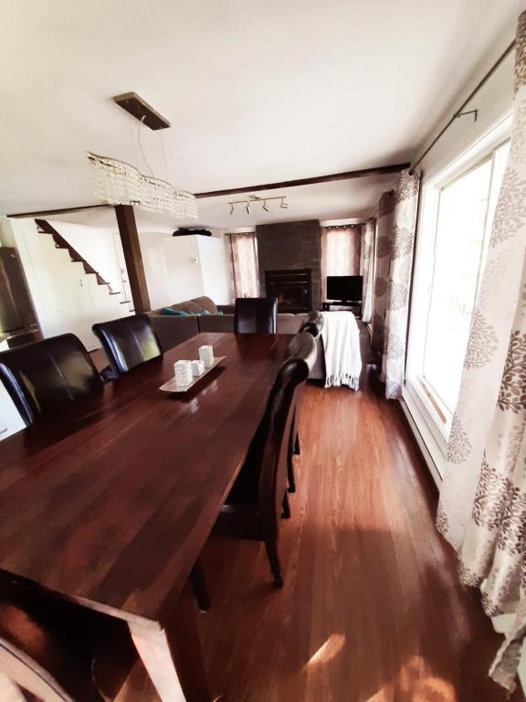 a dining room with a large wooden table and chairs at Chalet Le Pélican in Lac-Superieur