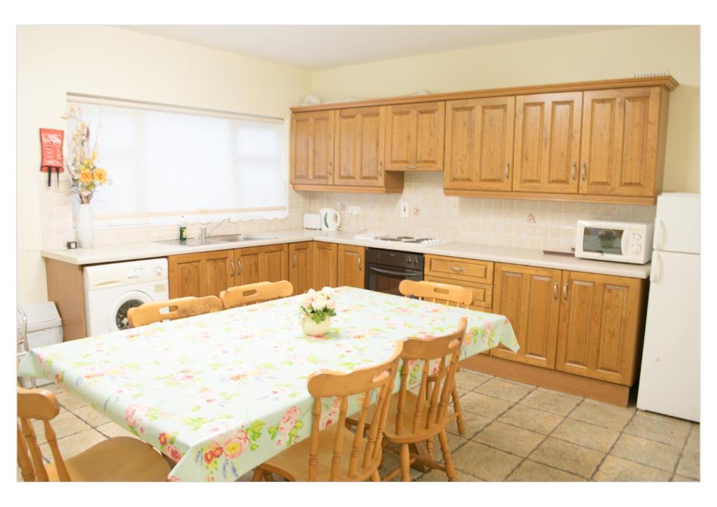 uma cozinha com mesa e cadeiras e uma cozinha com armários de madeira em no 3 Leitrim Road em Carrick on Shannon