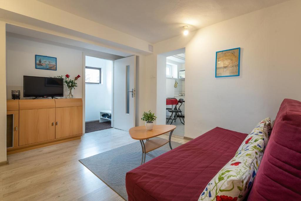 a living room with a red couch and a table at Apartman Katka in Poprad