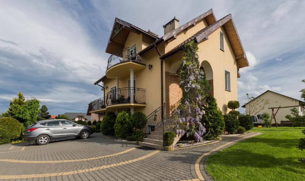 a house with a car parked in front of it at Pokoje u Joli Polańczyk in Polańczyk