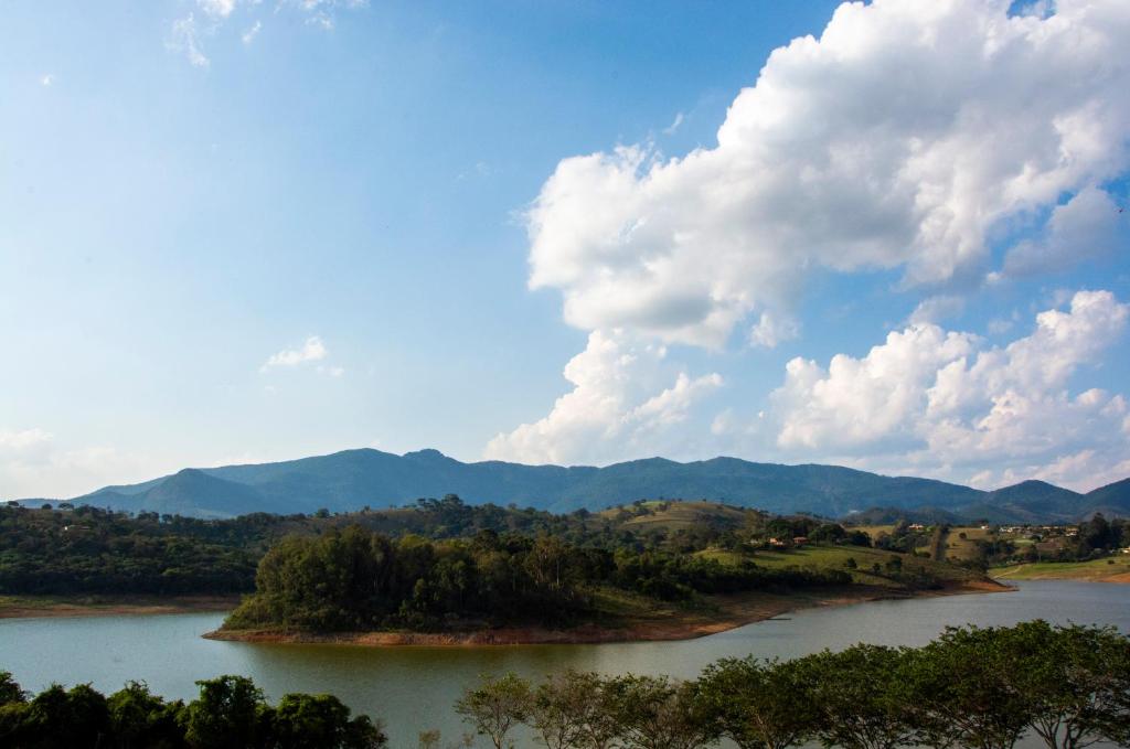 two islands in a river with mountains in the background at Pousada San Lorenzo in Joanópolis