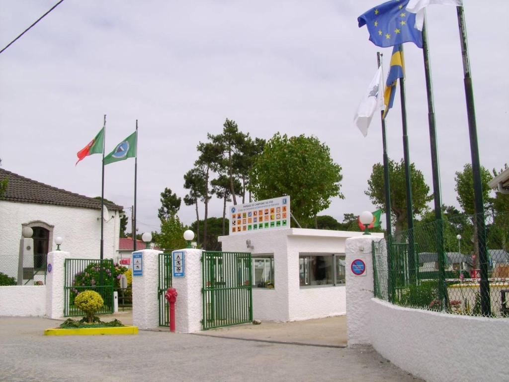 un bâtiment avec une porte et des drapeaux devant lui dans l'établissement Parque de Campismo de Fão, à Fão