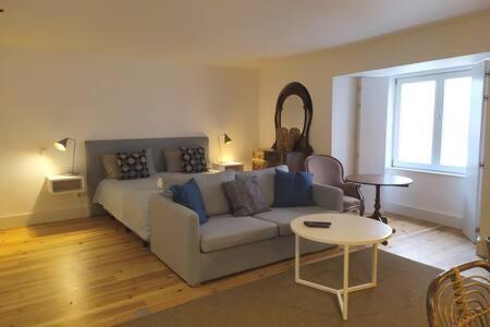 ein Wohnzimmer mit einem Sofa und einem Tisch in der Unterkunft Lisbon Combro 77 Charming Studios by Get Your Stay in Lissabon