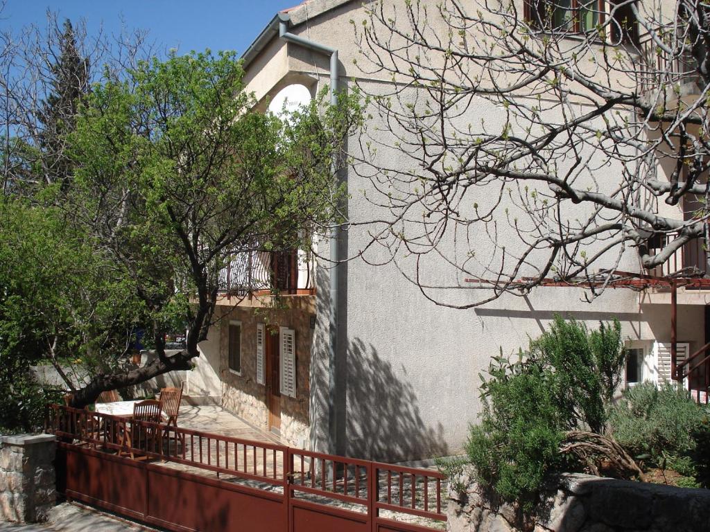 ein Gebäude mit einem roten Zaun davor in der Unterkunft Apartments Mia in Starigrad-Paklenica