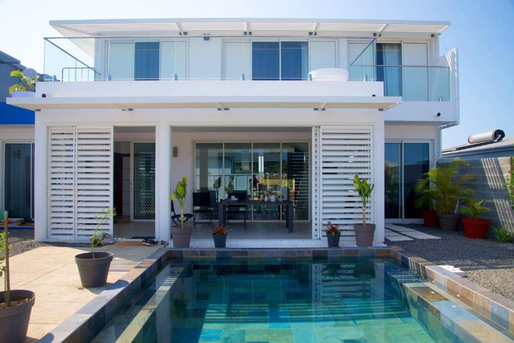 ein Haus mit einem Pool vor einem Haus in der Unterkunft Maison TONGA piscine - jacuzzi confort in Saint-Pierre