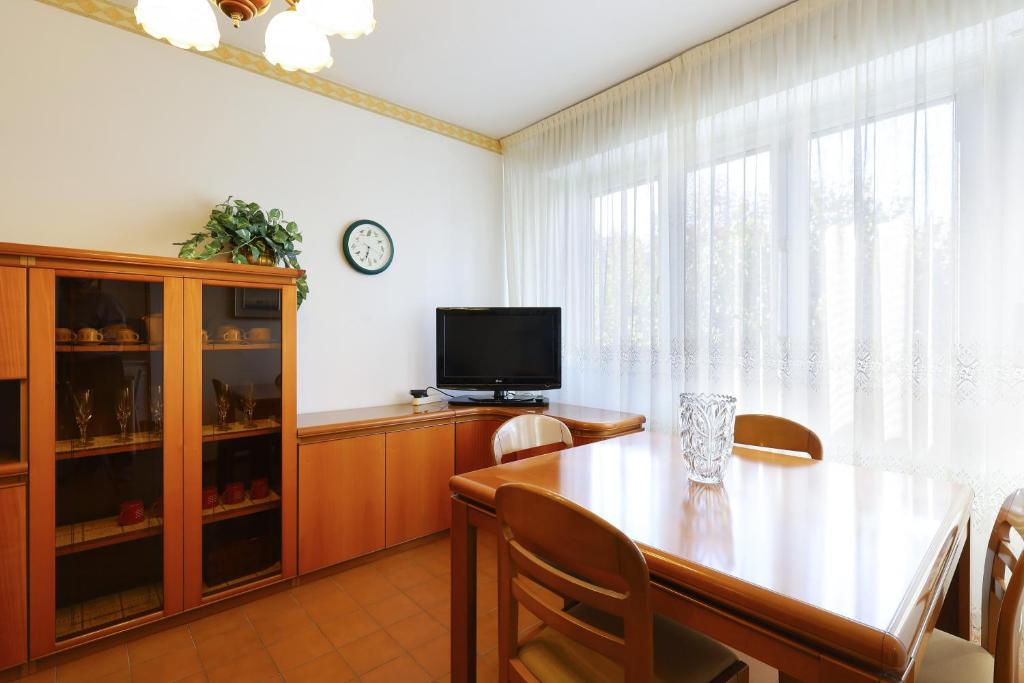 une salle à manger avec une table et une télévision dans l'établissement PrimoPiano - San Dionigi, à Milan