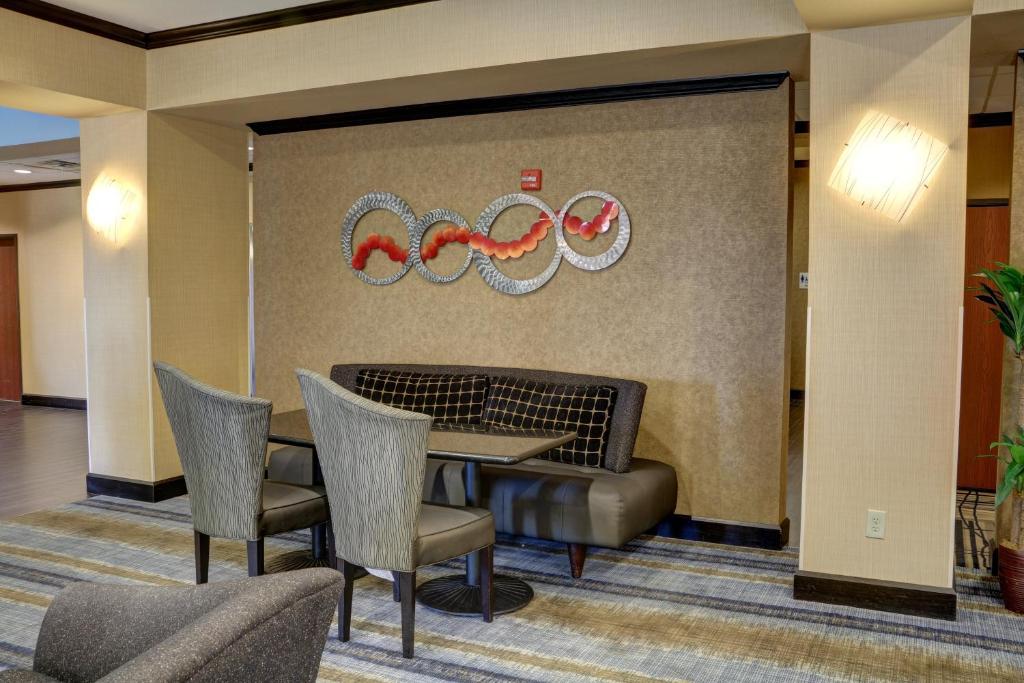 a lobby with a table and chairs and olympics on the wall at Holiday Inn Express Hotel & Suites Texarkana East by IHG in Texarkana