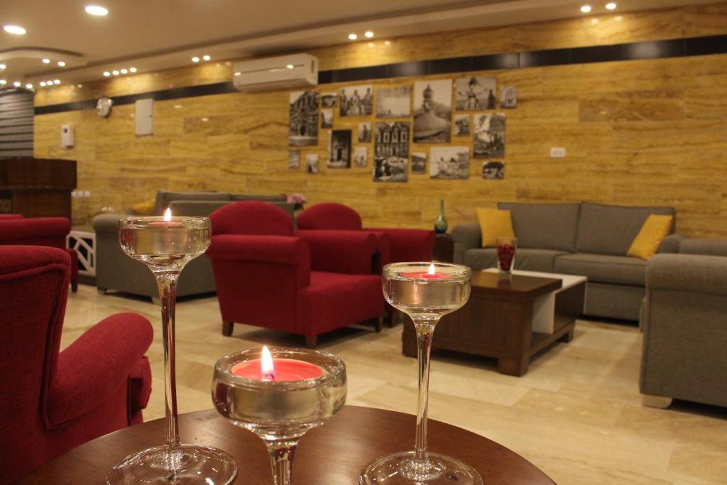 dos copas de vino sentadas en una mesa en un restaurante en Petra Corner Hotel en Wadi Musa