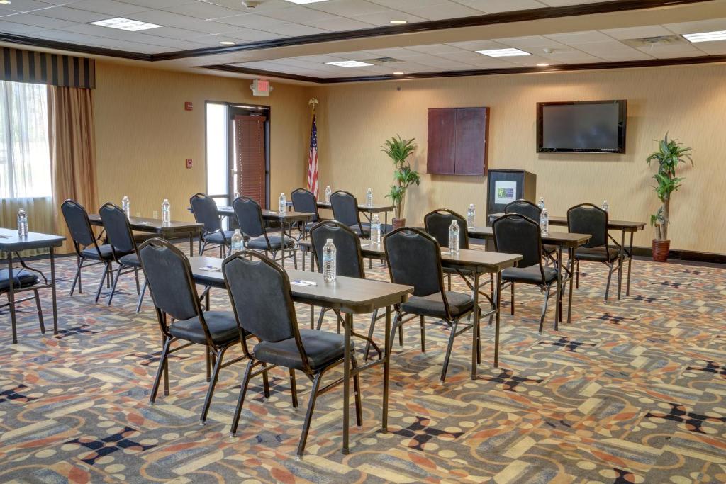 a conference room with tables and chairs and a screen at Holiday Inn Express Hotel & Suites Texarkana East by IHG in Texarkana
