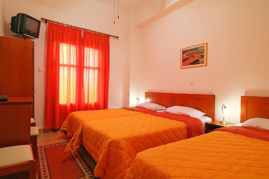 Habitación de hotel con 2 camas y ventana en Sibylla Hotel, en Delfos