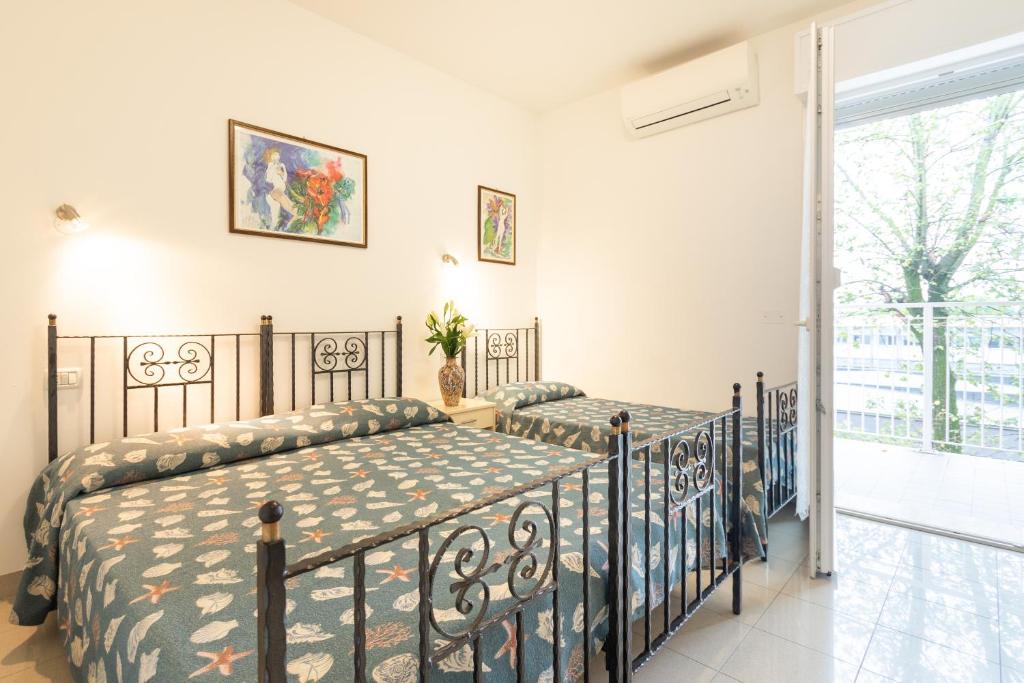 1 dormitorio con 2 camas y balcón en Villa Lucchese, en Lignano Sabbiadoro