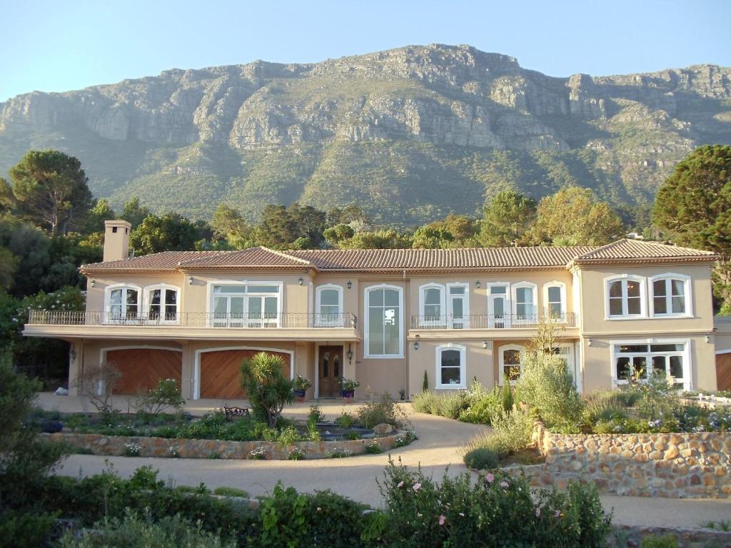 a large house with a mountain in the background at Chateau Neuf du Cap in Hout Bay
