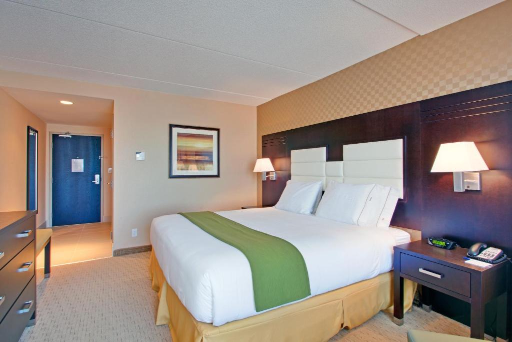 a hotel room with a large bed and a desk at Holiday Inn Express & Suites Ottawa West - Nepean by IHG in Ottawa
