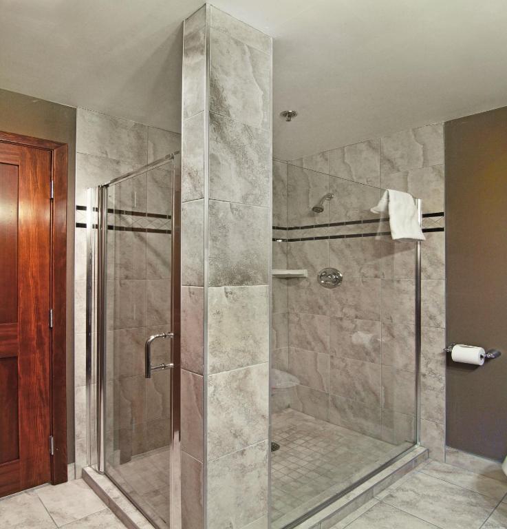 a shower with a glass door in a bathroom at Holiday Inn Express and Suites Calgary by IHG in Calgary