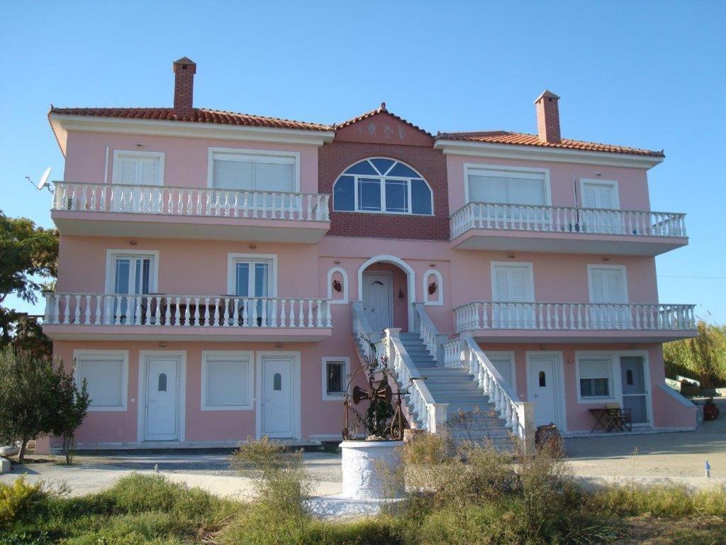 een groot roze huis met een trap ervoor bij Villa Lagosta in Város