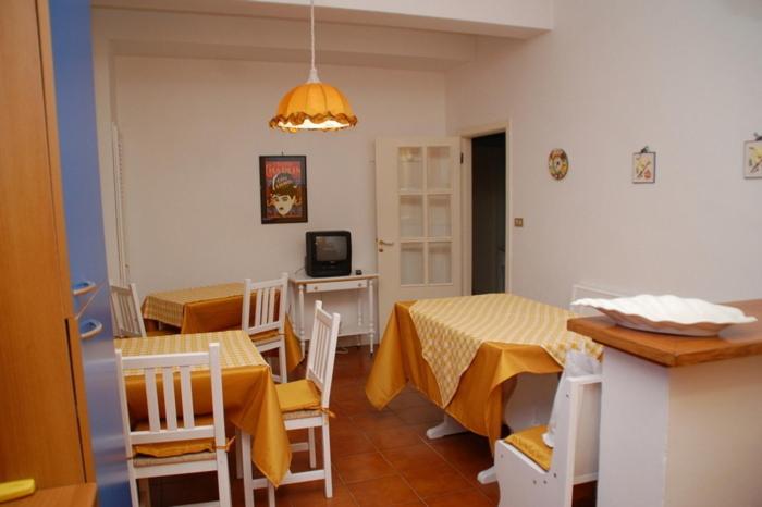 cocina y comedor con 2 mesas y sillas en B&B Milù, en Civitanova Marche