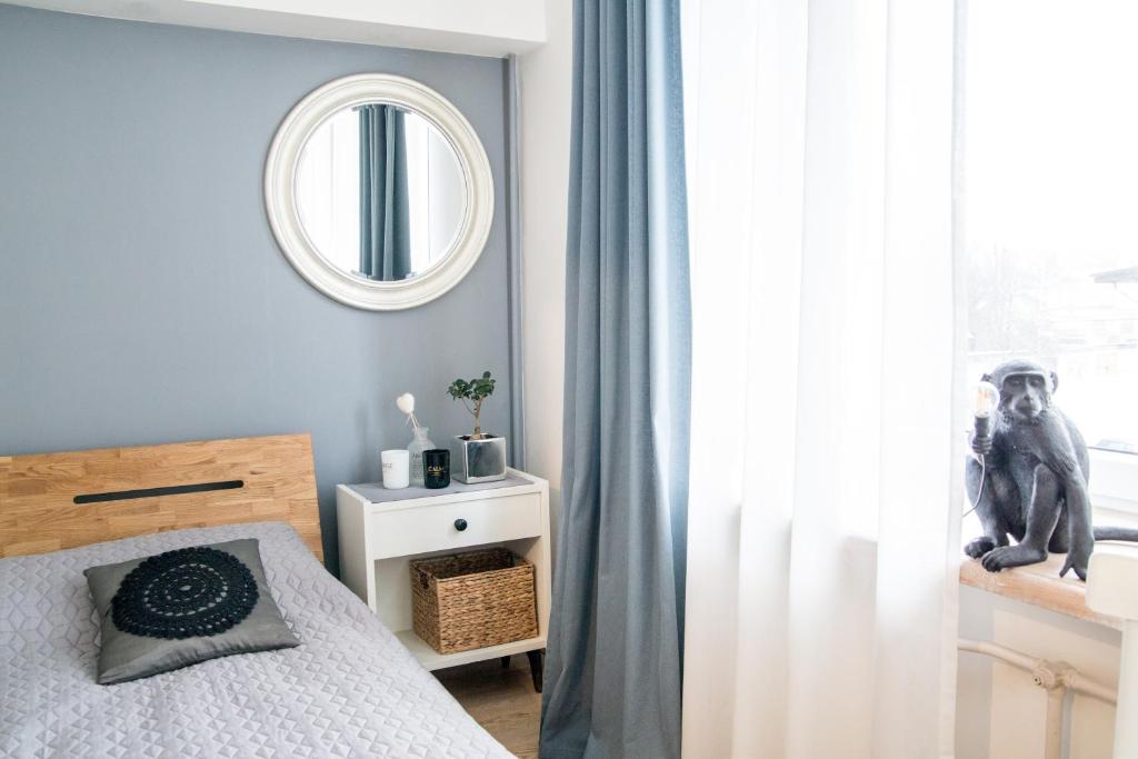 Schlafzimmer mit einem Bett, einem Spiegel und einem Fenster in der Unterkunft Downtown Apartment Rentals in Šiauliai