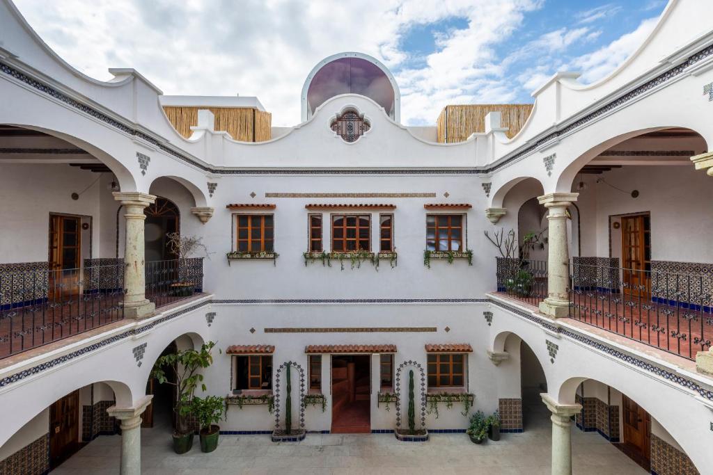 Elle offre une vue sur l'extérieur d'un bâtiment blanc doté d'un balcon. dans l'établissement Grana B&B, à Oaxaca