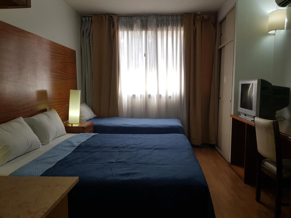 Habitación de hotel con 2 camas y TV en Al Porteño en Buenos Aires