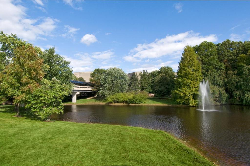 a view of a pond with a fountain and a bridge at Holiday Inn Express Princeton Southeast, an IHG Hotel in Plainsboro