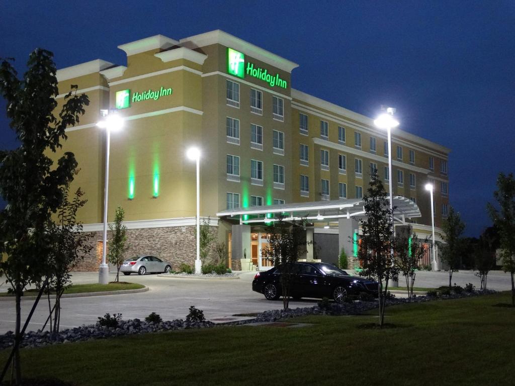 a hotel with green lights in a parking lot at night at Holiday Inn Covington, an IHG Hotel in Covington
