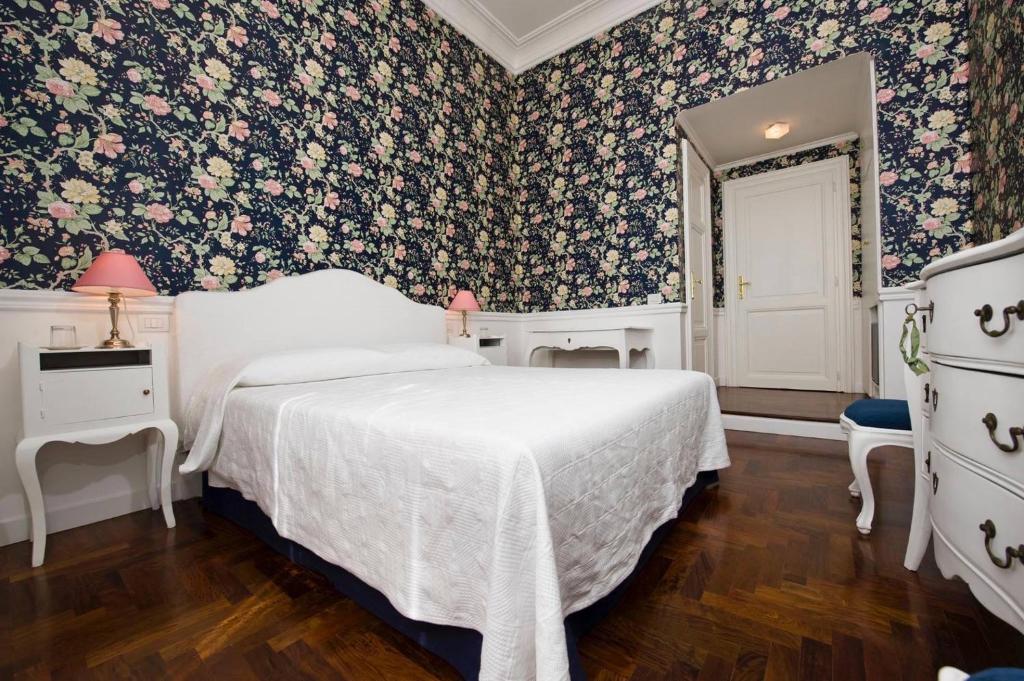 um quarto com uma cama e papel de parede floral em B&b Querini em Roma