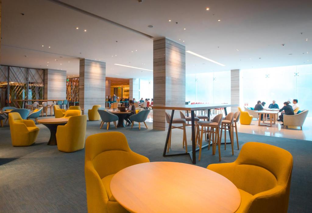 a restaurant with tables and chairs and people in the background at Holiday Inn Express Manila Newport City, an IHG Hotel in Manila