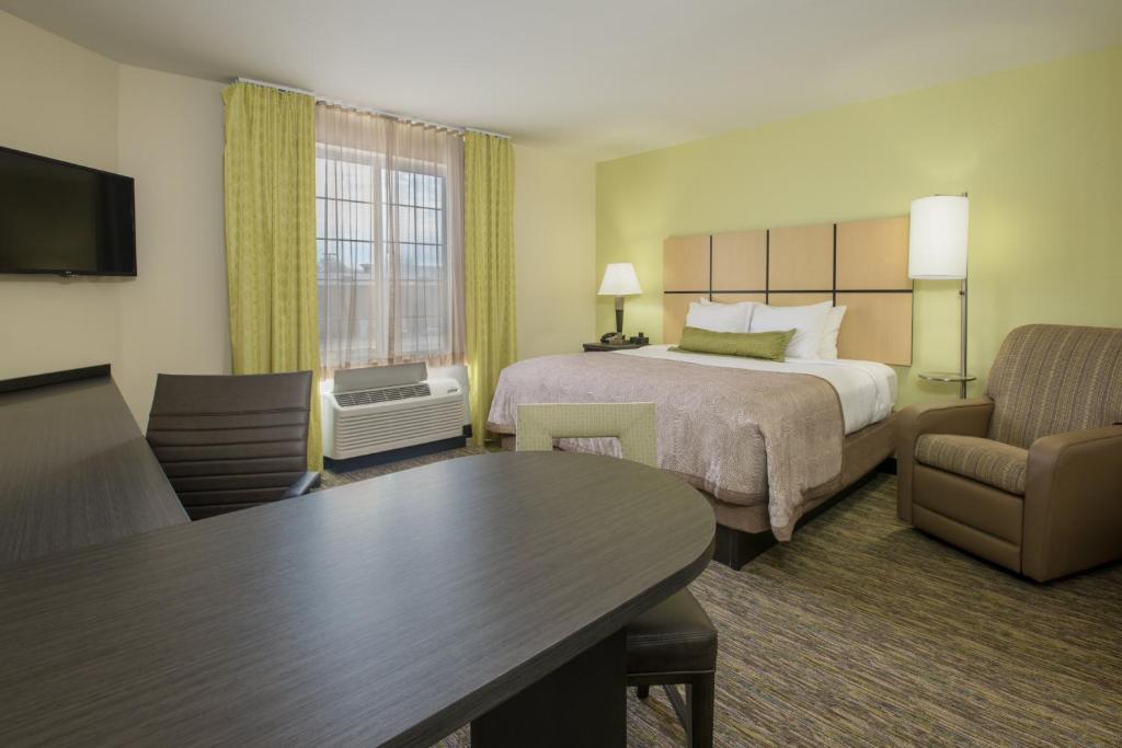 um quarto de hotel com uma cama e uma sala de estar em Candlewood Suites Del City, an IHG Hotel em Del City