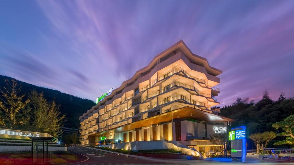 een weergave van een hotelgebouw 's nachts bij Holiday Inn Express Qiliping, an IHG Hotel in Emeishan