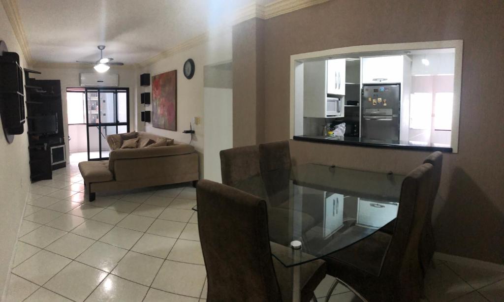 una sala de estar con una mesa y un sofá en LINDO APARTAMENTO EM MEIA PRAIA-1 quadra do mar! Melhor localização!, en Itapema