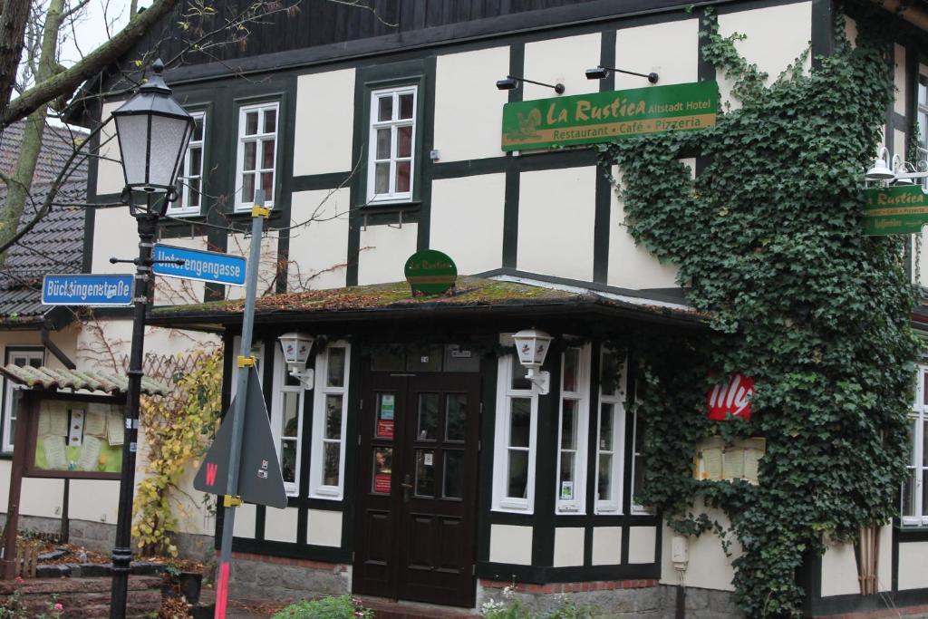 ein schwarzweißes Gebäude mit einem Schild darauf in der Unterkunft La Rustica Altstadthotel in Wernigerode