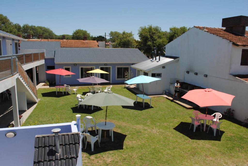 um pátio exterior com mesas, cadeiras e guarda-sóis em Ayuntunhue Apart Hotel em San Bernardo