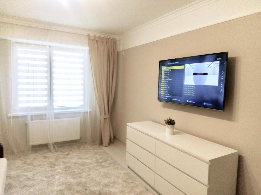 a living room with a tv and a white dresser at Sofia’s Apartment in Chişinău