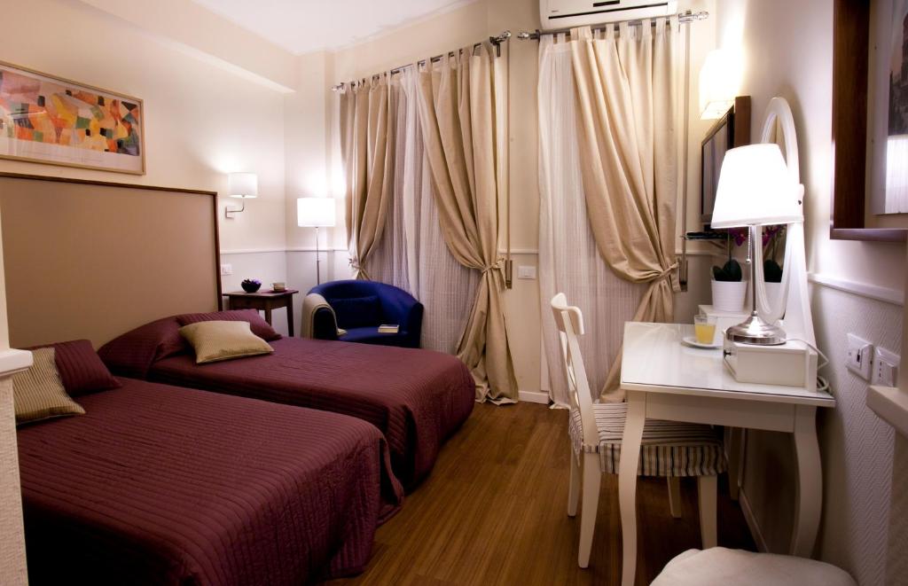 een hotelkamer met 2 bedden en een bureau bij Colfelice Rooms in Rome